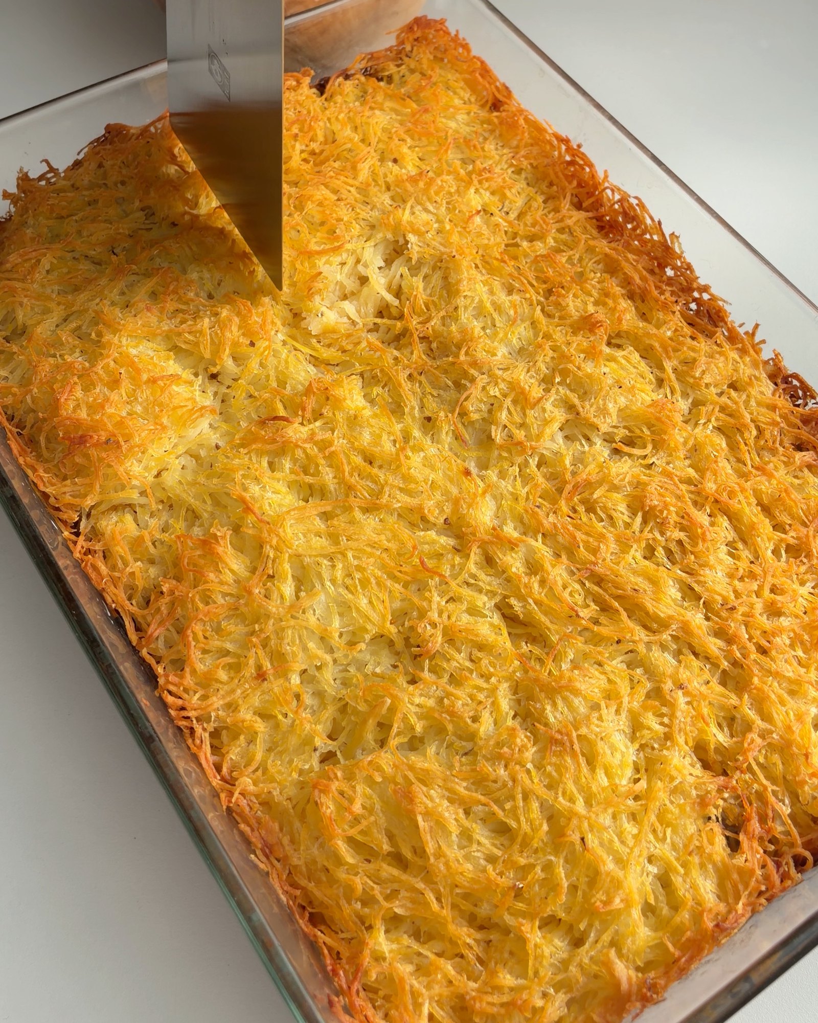 O empadão acabado de sair do forno, com a camada de batata ralada dourada e estaladiça por cima