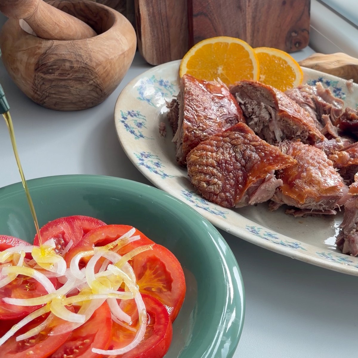 O peru cortado numa travessa, ao lado de uma salada de tomate e cebola